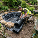 HDPE pond liner being installed in UK garden pond by landscaper