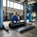 SBR rubber sheet being rolled out in commercial garage workshop under vehicle lift